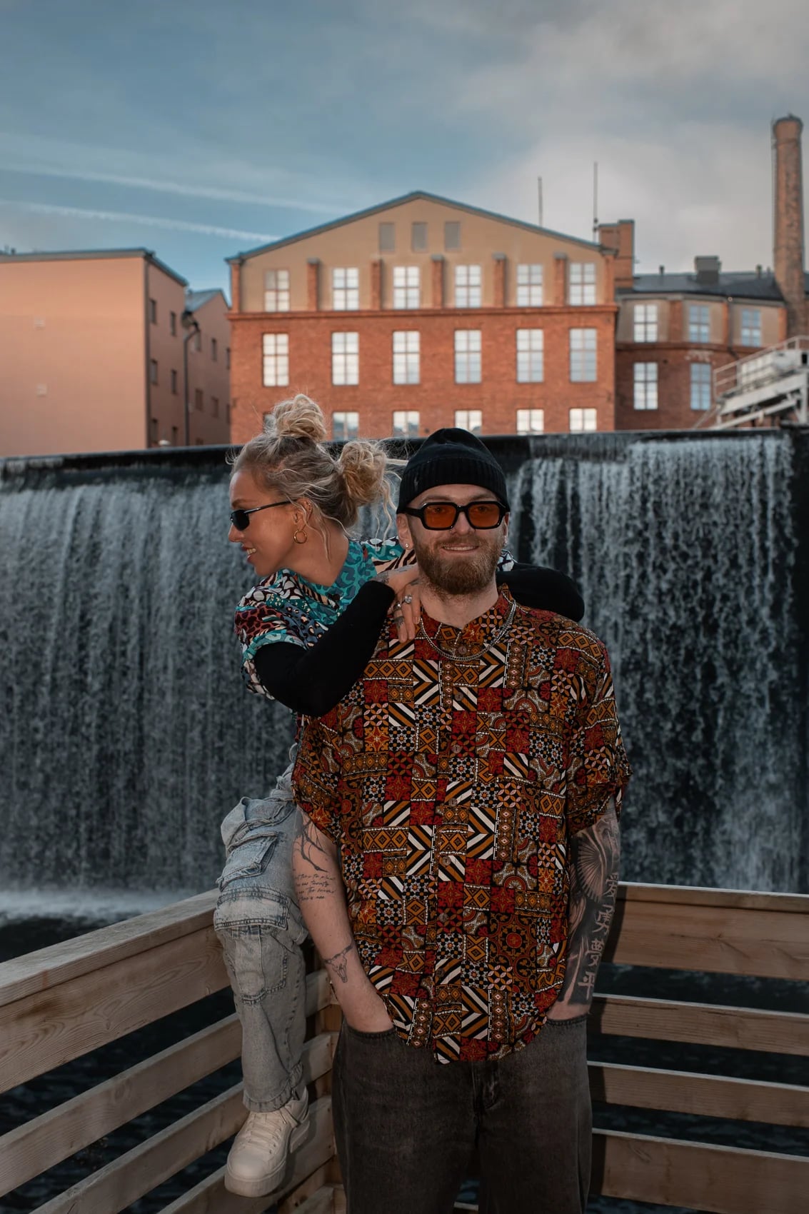 Two people in 2CC prints in front of the Norrköping waterfall