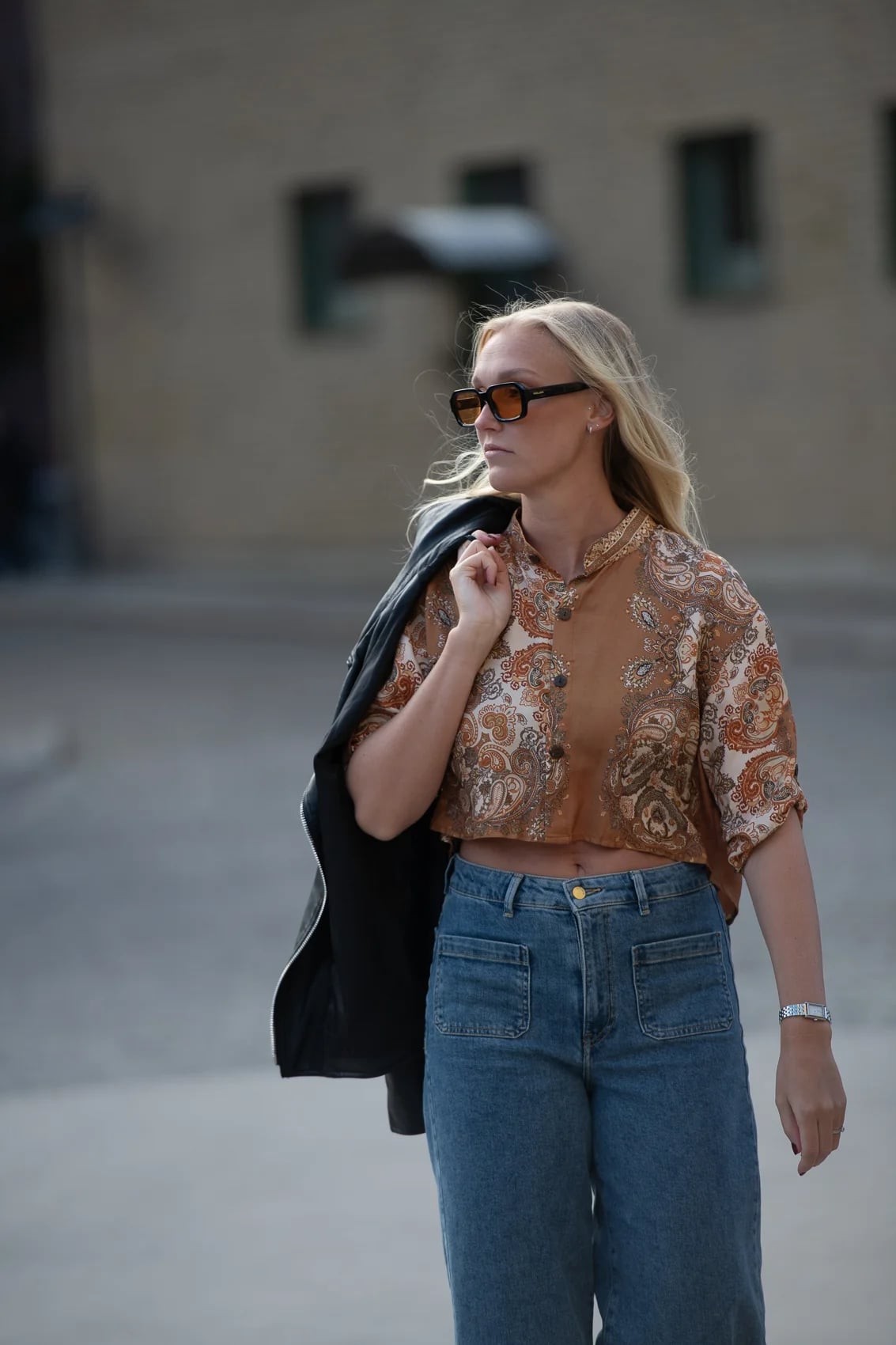 2CC printed shirt layered under a leather jacket on a Swedish city street